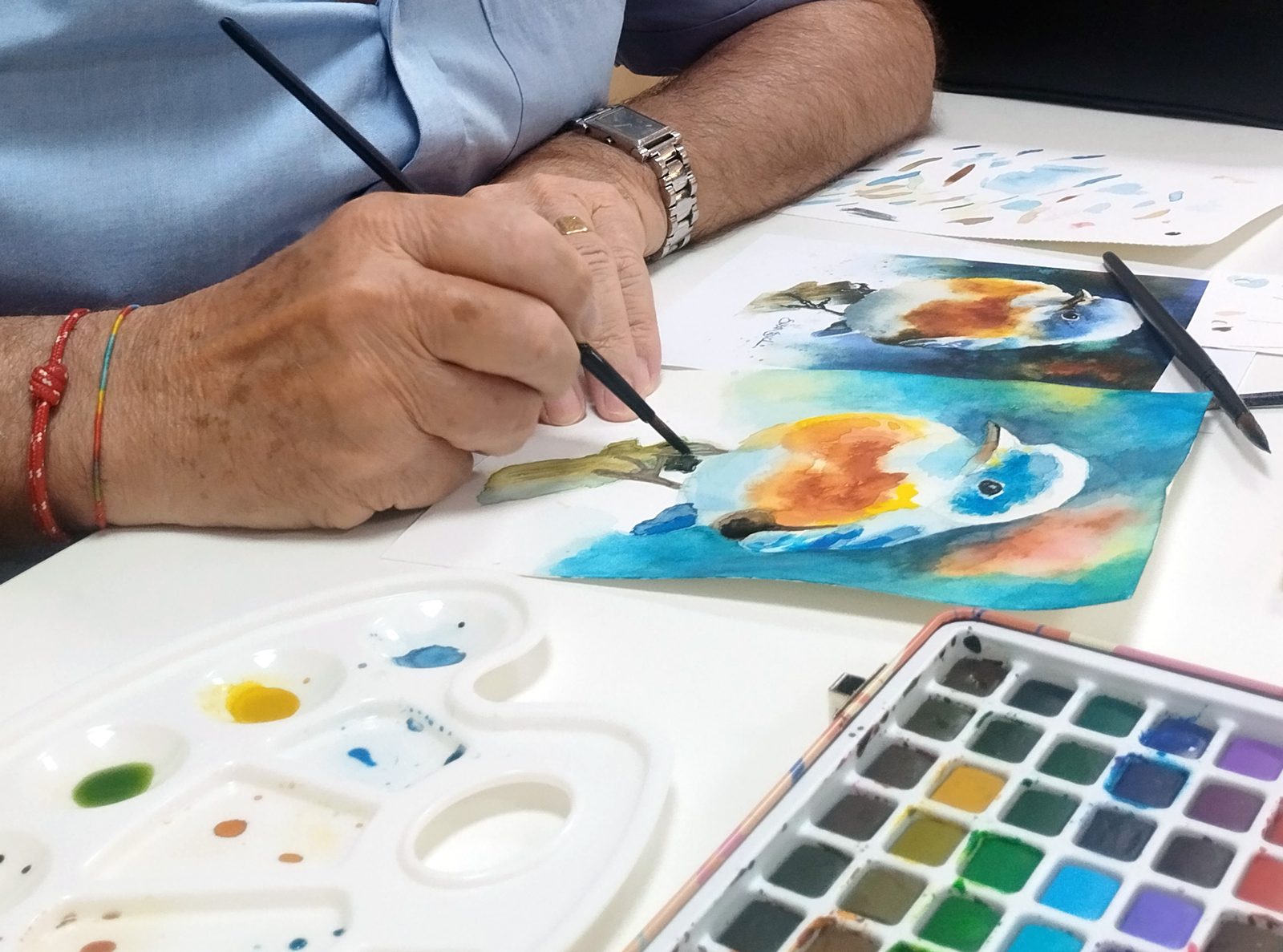 Alumno adulto pintando un pájaro en acuarela en un taller de pintura de Ana Toribio en Sevilla Este
